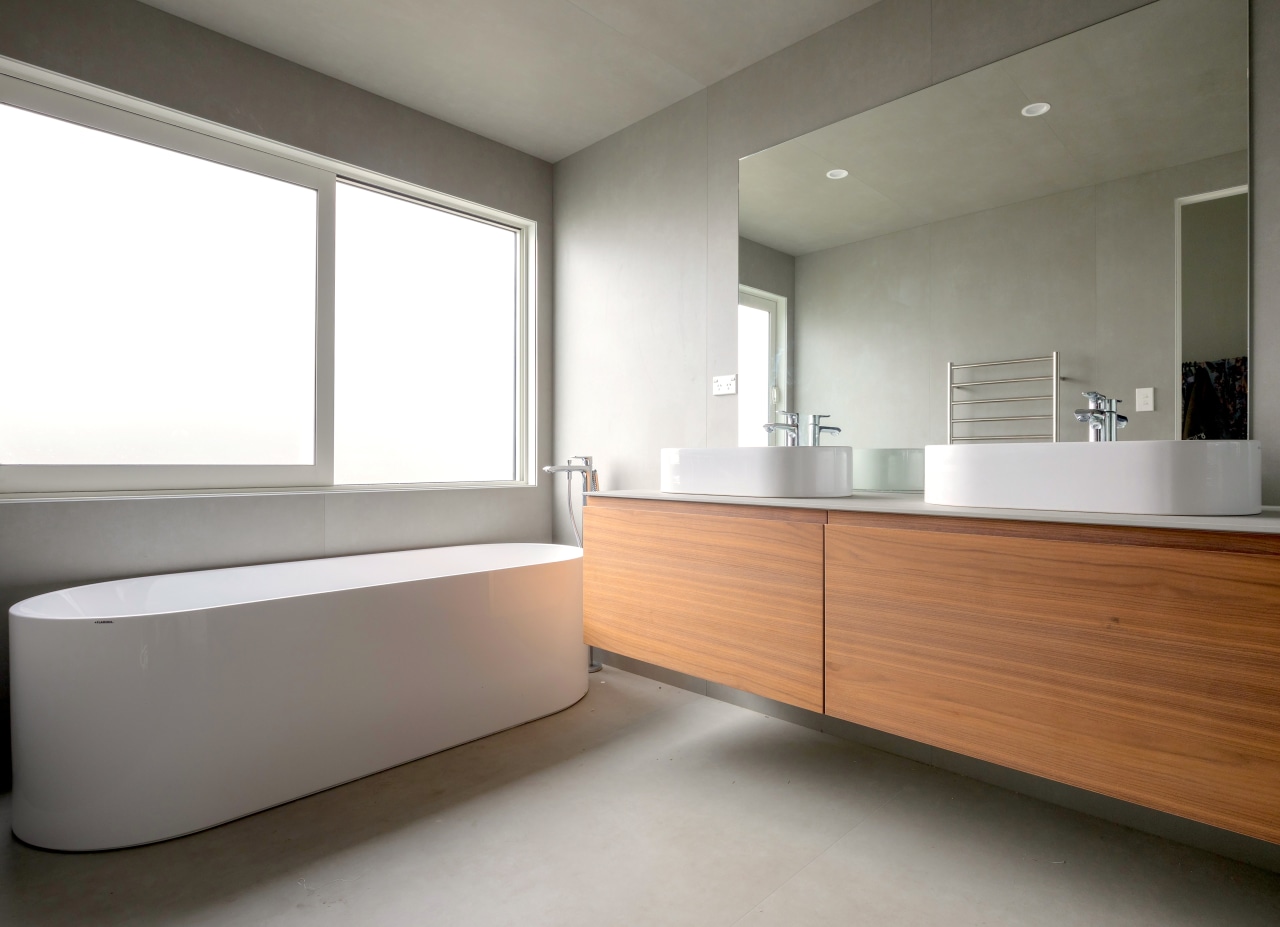 A clean-lined wall-hung vanity contrasts a curvaceous freestanding architecture, bathroom, building, cabinetry, ceiling, daylighting, floor, flooring, furniture, home, house, interior design, material property, property, real estate, room, sink, gray, white