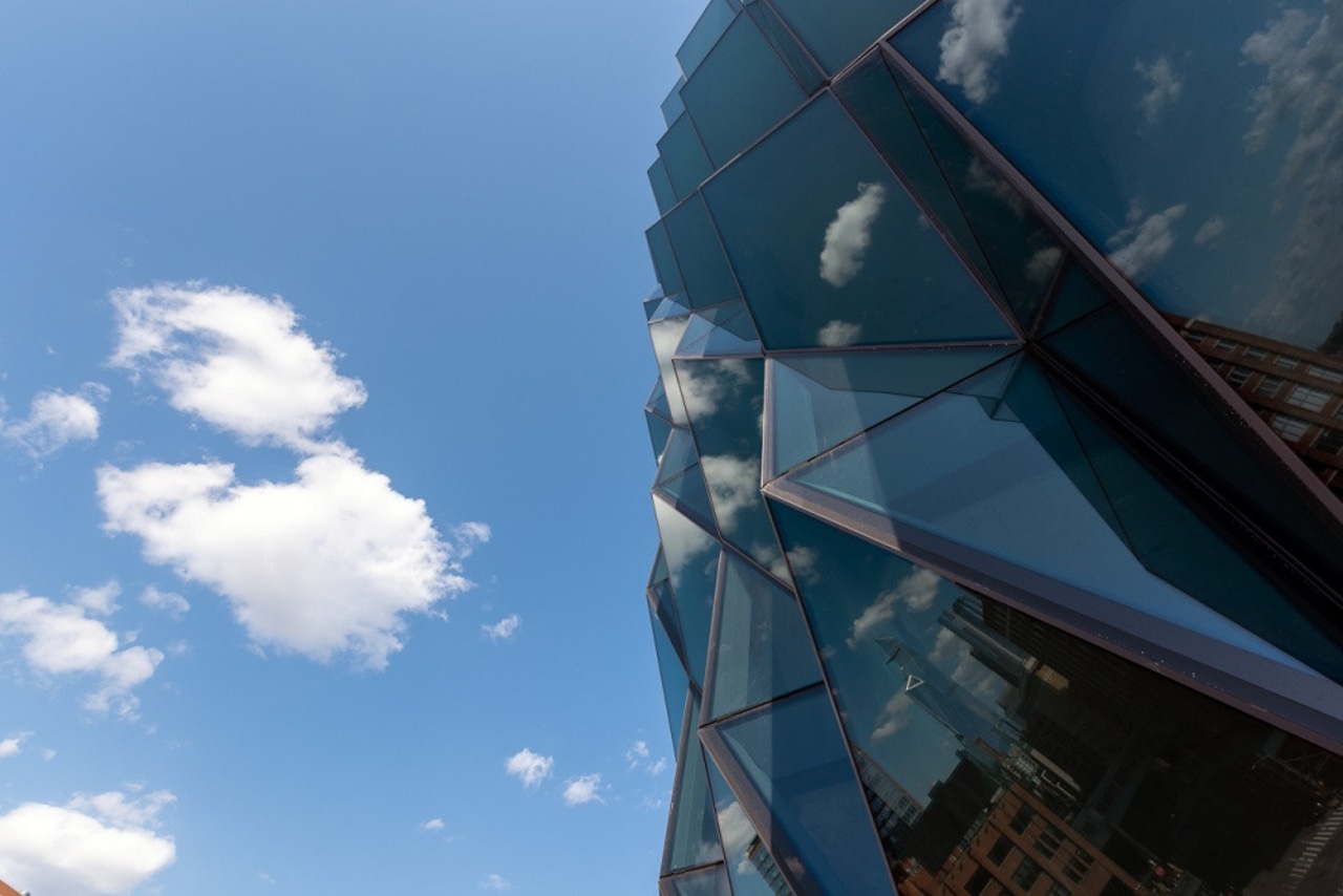 The facade features high-performance glass with low reflectivity. architecture, blue, city, cloud, daytime, glass, photography, reflection, sky, sunlight, urban area, teal, blue