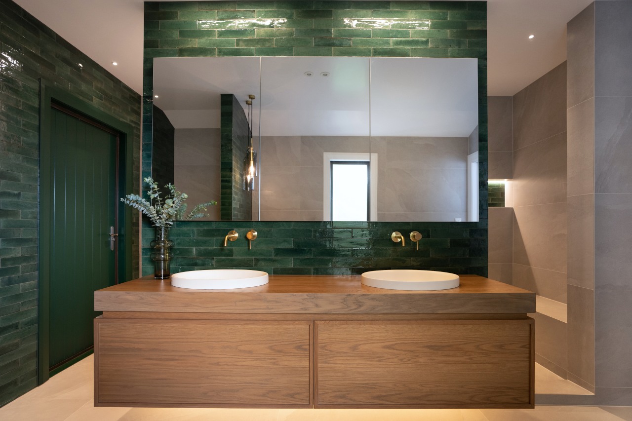 The bespoke oak timber vanity, with mirror reflecting 