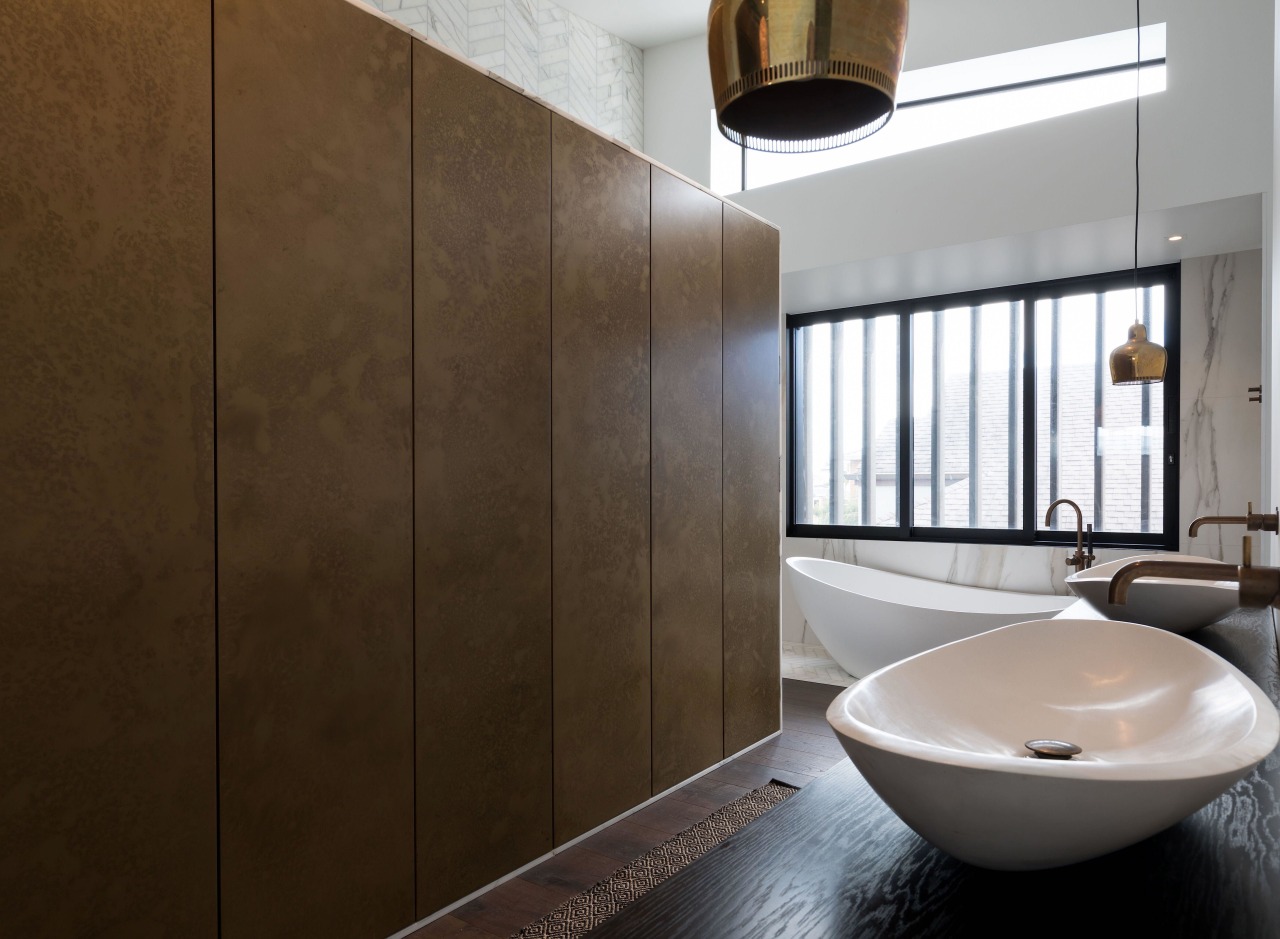 This metal-look dividing wall incorporates push-to-open cabinetry with brown