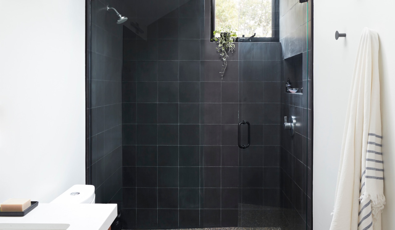 The primary bathroom showcases floor-to-ceiling tiles and a 