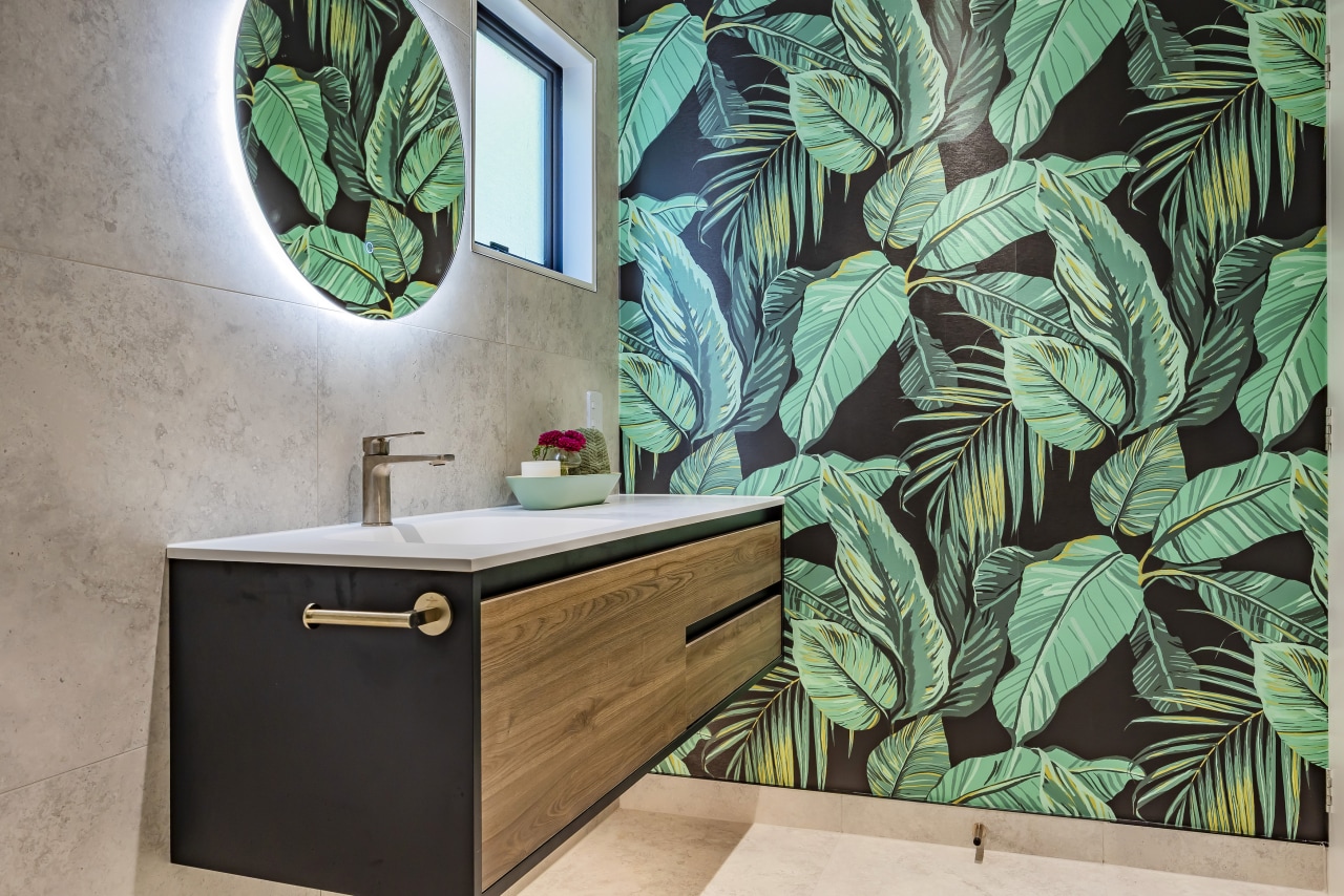 The cantilevered wood vanity complements the dramatic tropical 