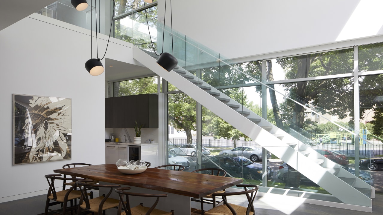 An open riser steel and glass staircase connects architecture, building, ceiling, daylighting, design, dining room, floor, flooring, furniture, glass, home, house, stairs, staircase, interior design, lighting, living room, loft, property, real estate, room, shade, table, window, gray, white