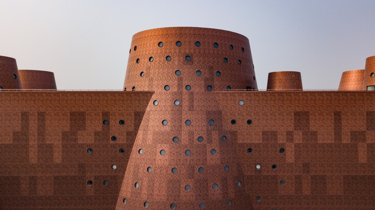 The copper-look facade is actually aluminium cladding.  architecture, castle, fortification, historic site, wall, red