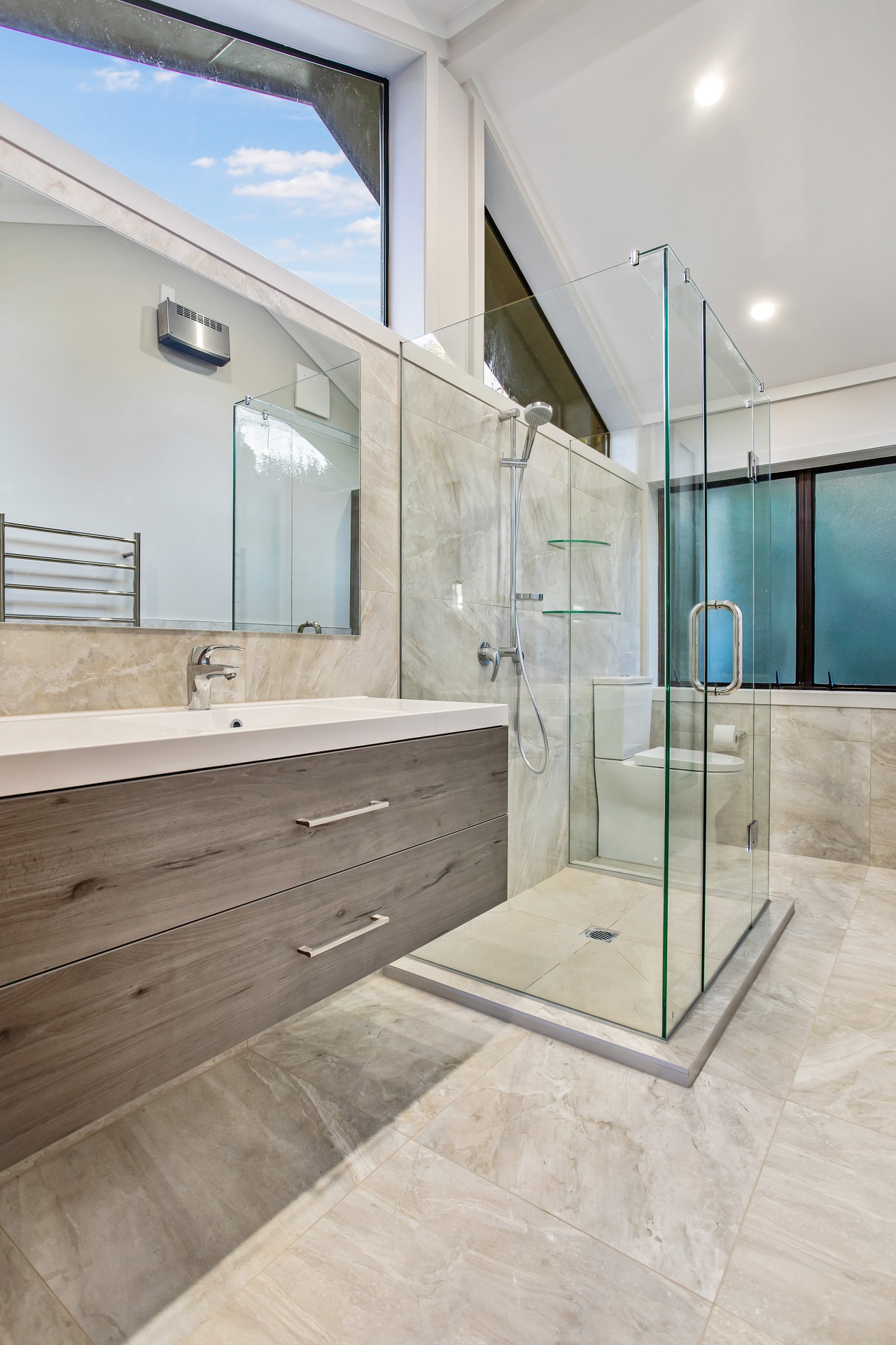 The cantilevered vanity and transparent glass shower stall apartment, architecture, bathroom, building, ceiling, daylighting, estate, floor, flooring, furniture, glass, home, house, interior design, property, real estate, room, space, tile, wall, window, gray