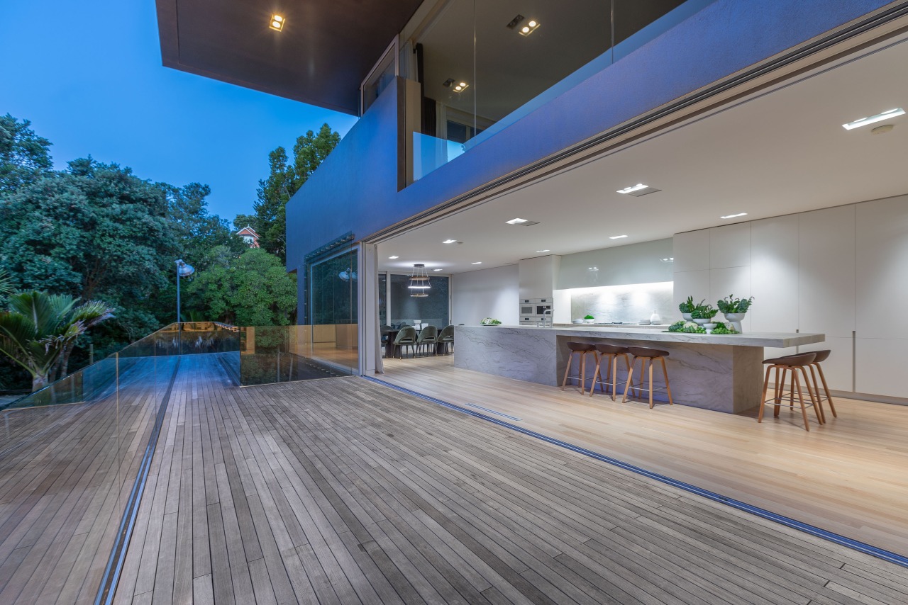 With floor-to-ceiling glass sliders drawn back the kitchen 