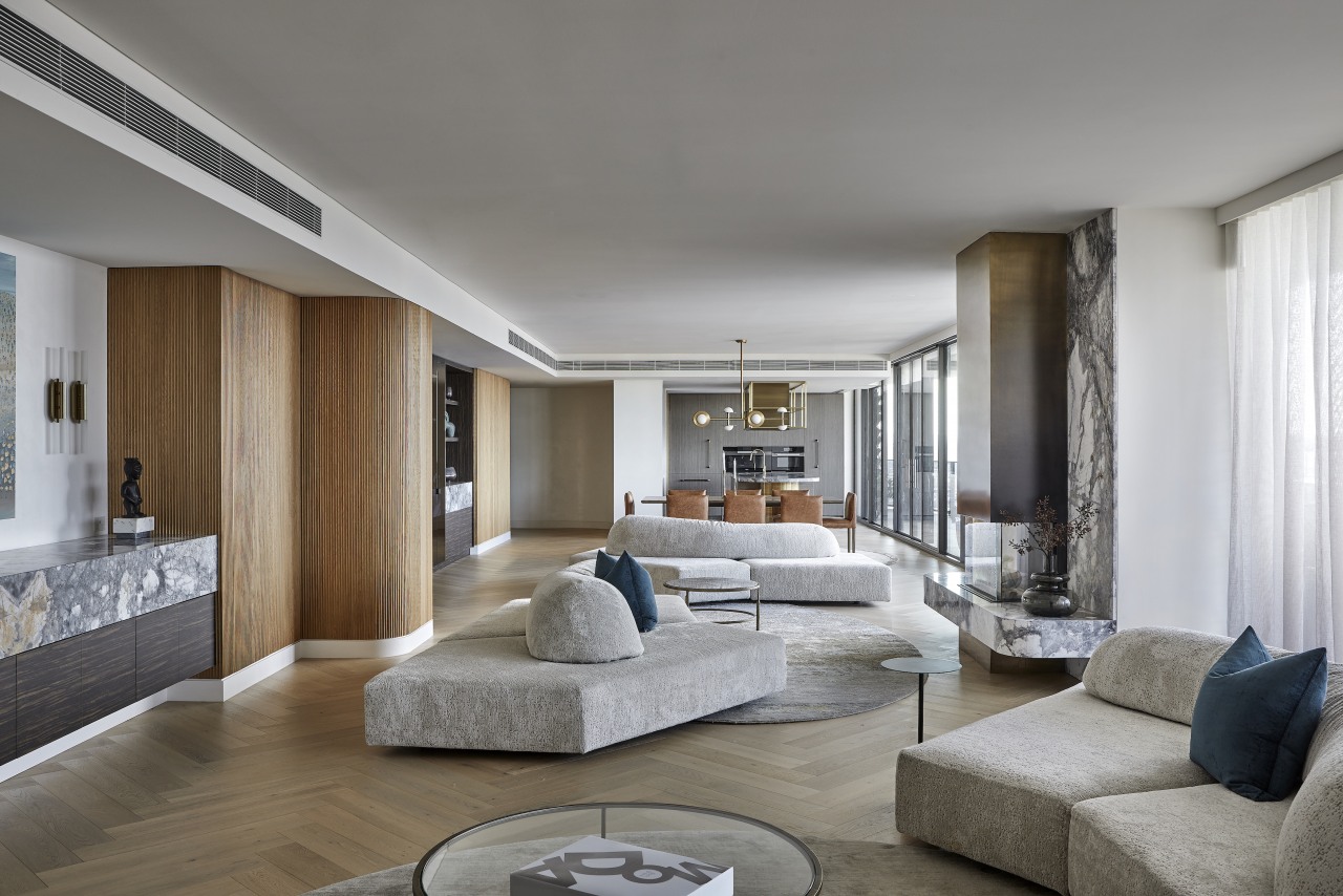 The monolithic stone fireplace with brass flue serves 