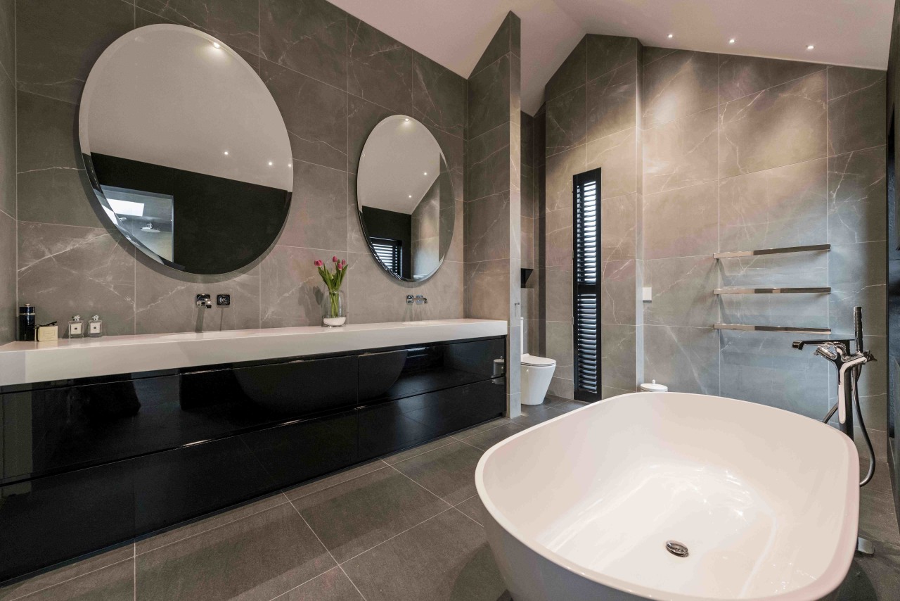 This bathroom fulfils the clients' request for a architecture, bathroom, bathroom sink, bathtub, building, ceiling, ceramic, floor, flooring, house, interior design, marble, mirror, plumbing fixture, property, real estate, restroom, room, sink, tap, tile, toilet, wall, gray, black