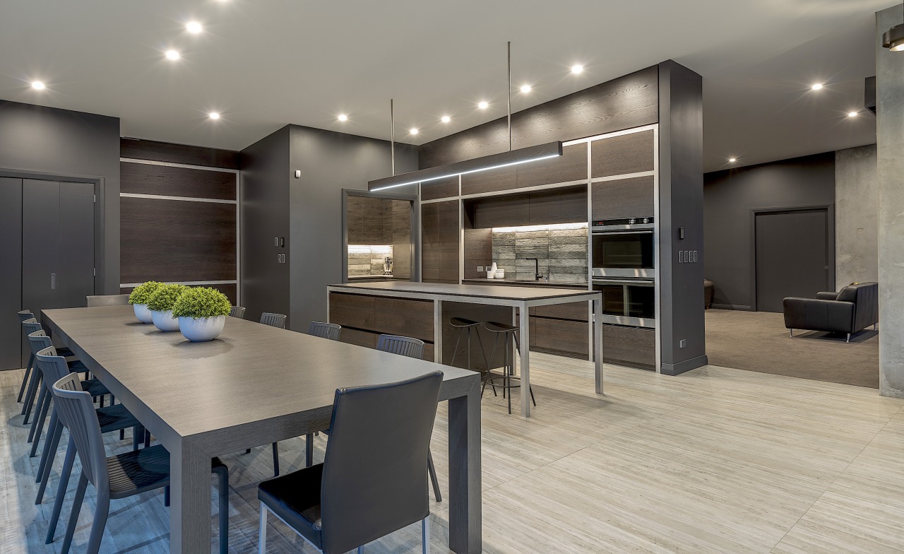 The kitchen cabinetry continues the aesthetic of the gray, black