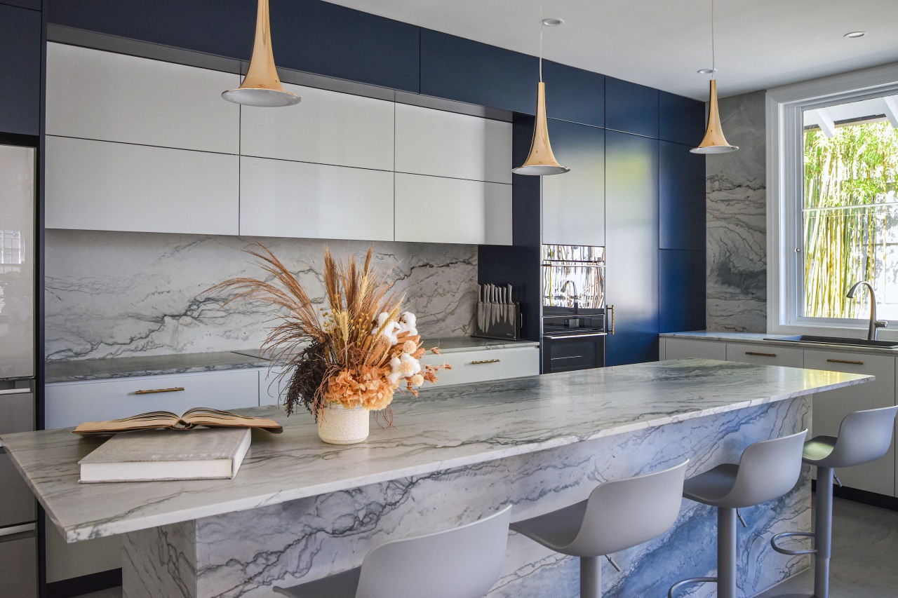 The kitchen's aesthetic comprises dark blue and grey 
