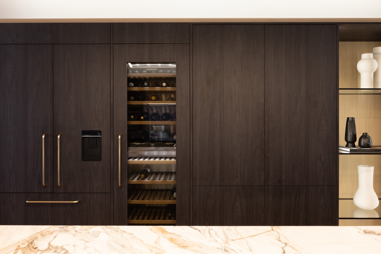 The wine fridge is integrated into the cabinetry 