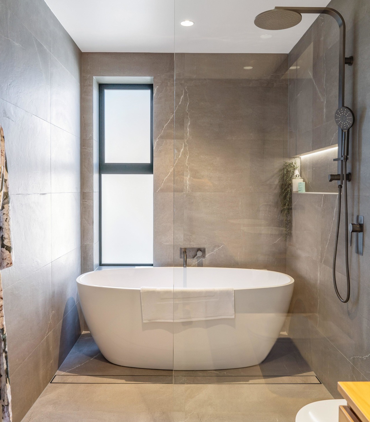 The freestanding tub is situated at the end 