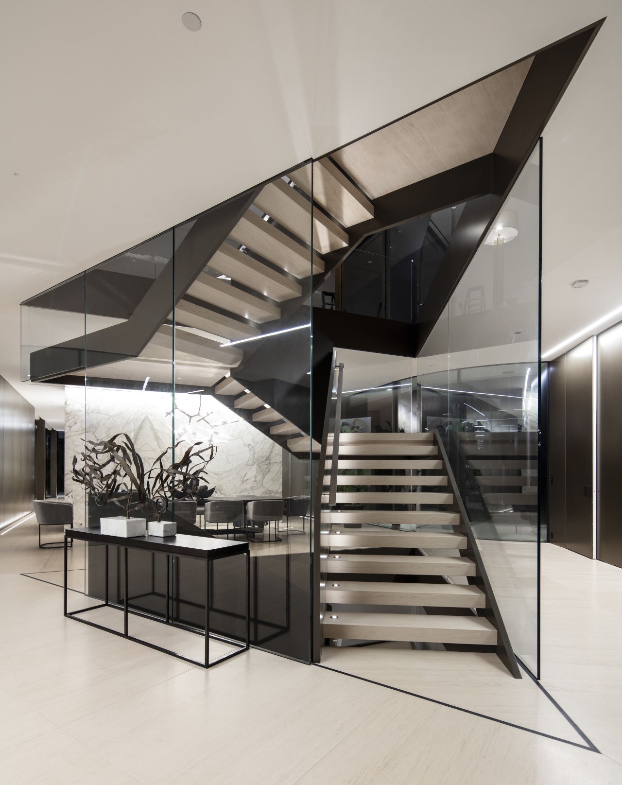 ​​​​​​​Visitors encounter a dynamic glass and steel staircase architecture, black-and-white, building, ceiling, daylighting, design, floor, limestone floor,  stair, staricase, glass, handrail, house, interior design, line, lobby, material property, metal, real estate, room, stairs, gray