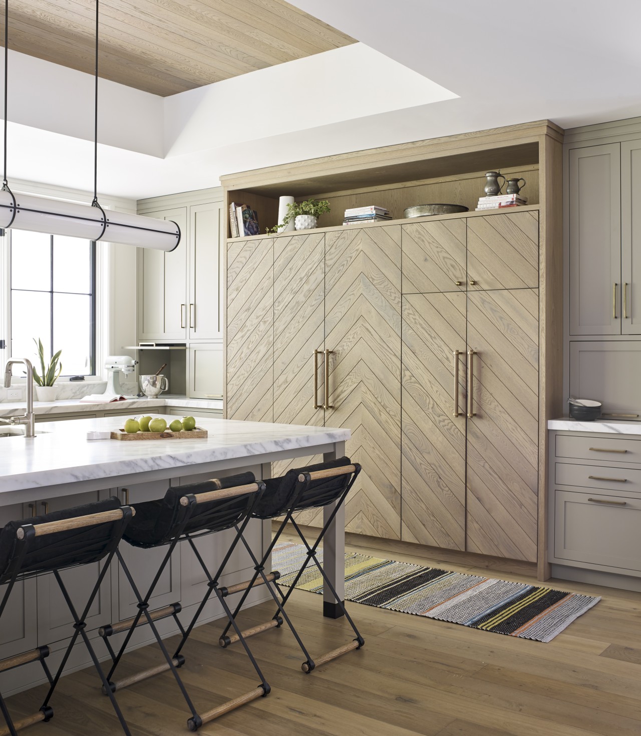 ​​​​​​​In this kitchen, classic paneled down-to-counter cabinetry hides 