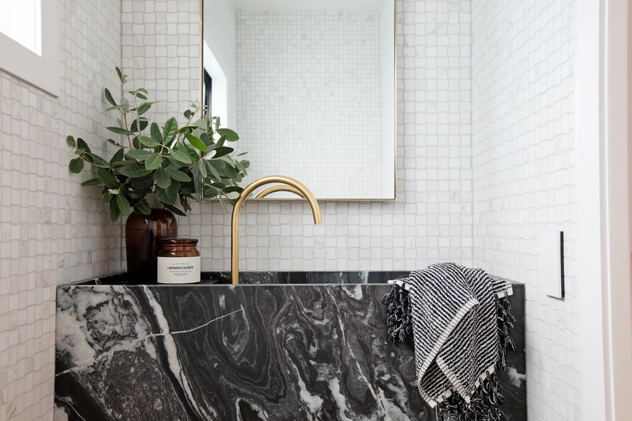 A limestone vanity, marble mosaics and brass tapware 