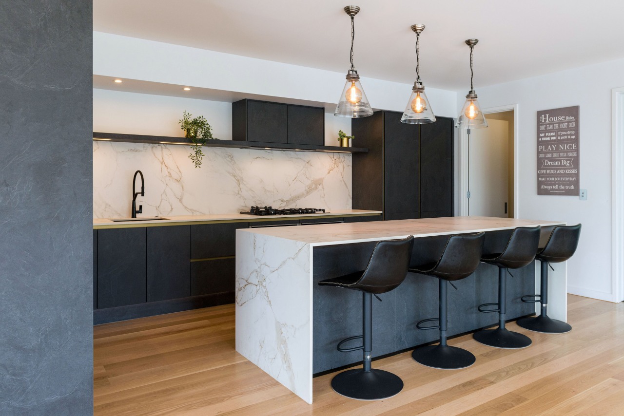 A slender waterfall benchtop adds to the kitchen's 