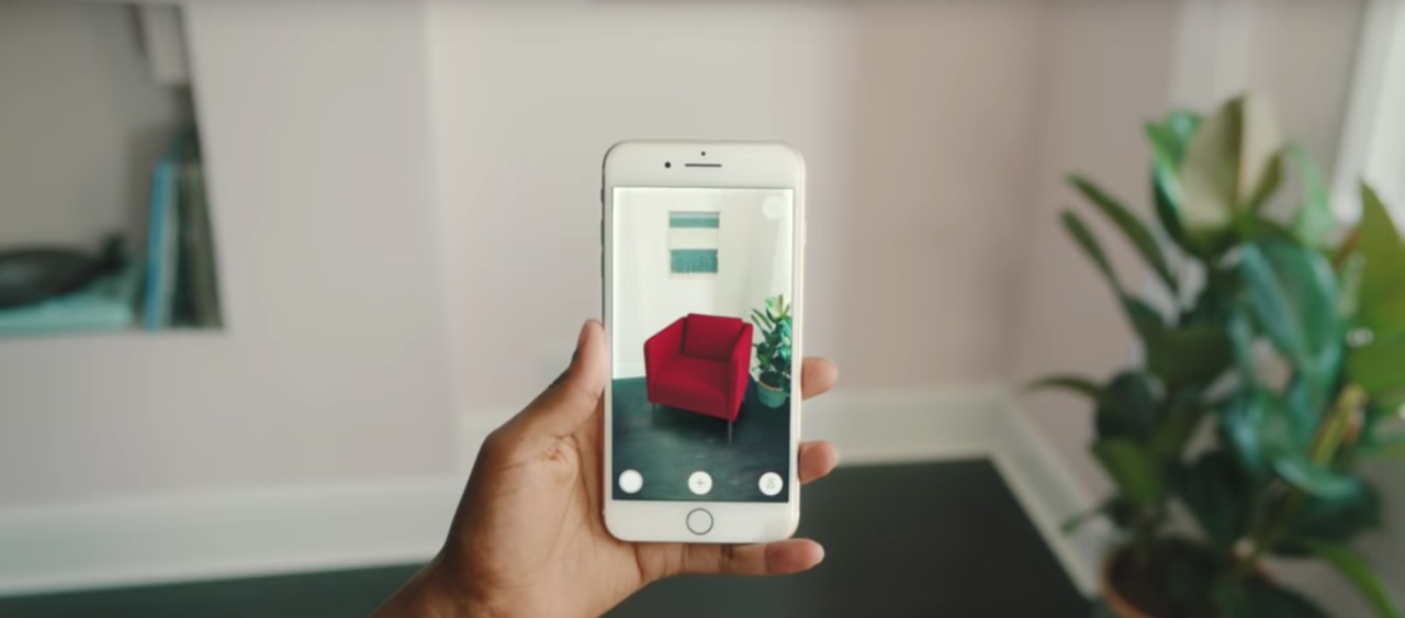 Ikea's Place app uses augmented reality communication device, electronic device, feature phone, finger, gadget, hand, iphone, mobile phone, photography, plant, portable communications device, red, smartphone, technology, telephone, gray