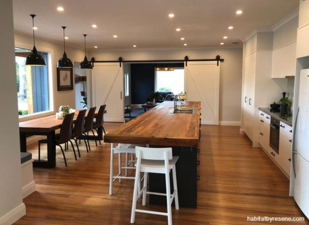 The interior of this Gisborne farmhouse is predominately building, cabinetry, ceiling, countertop, dining room, floor, flooring, furniture, hardwood, home, house, interior design, kitchen, laminate flooring, light fixture, lighting, property, real estate, room, table, wood, wood flooring, brown