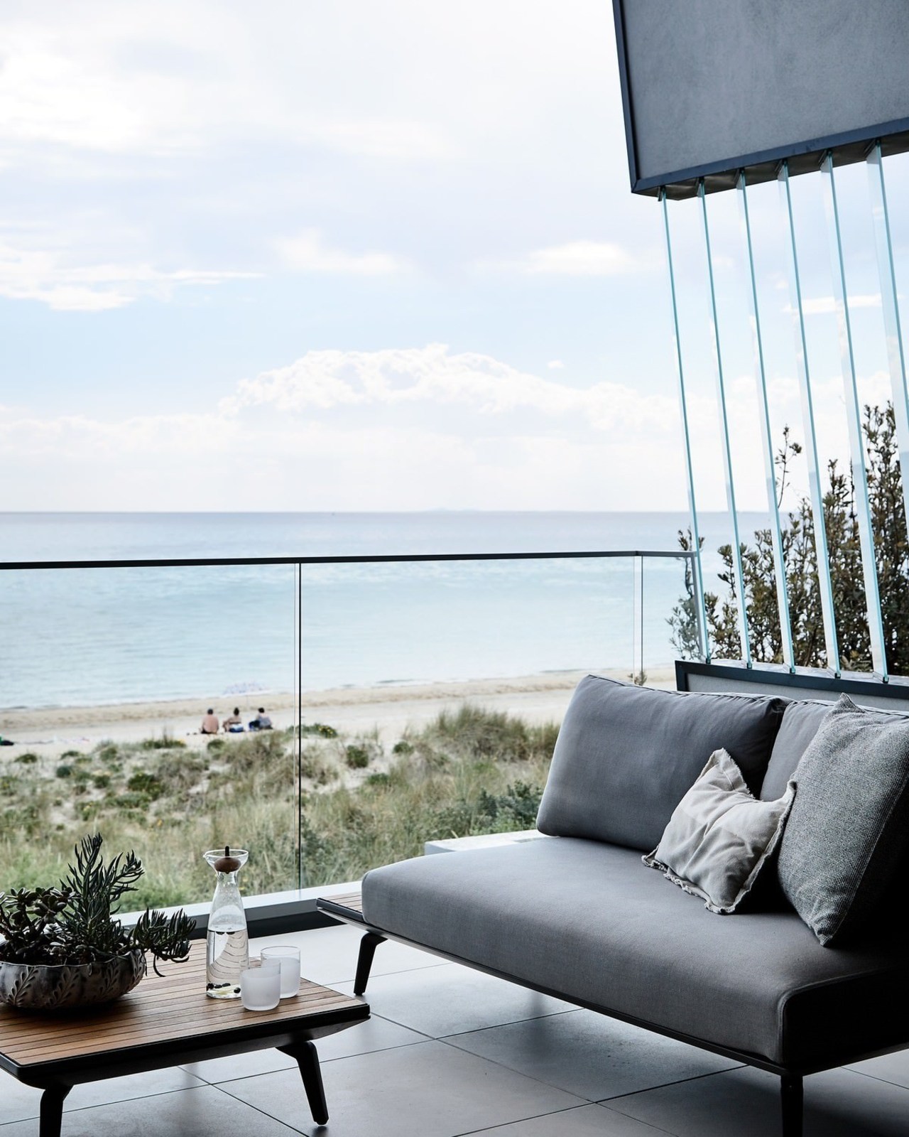 A glass balustrade keeps sea in full view chair, couch, furniture, home, interior design, living room, outdoor furniture, sea, sky, sunlounger, table, window, white