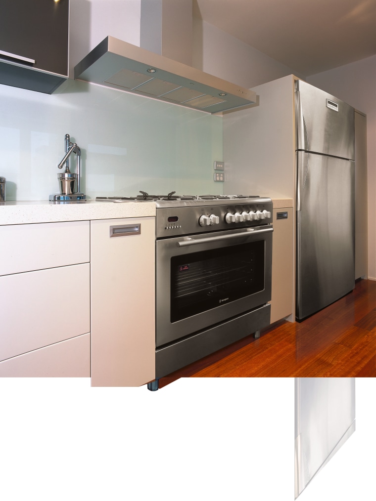 A view of a kitchen area, wooden flooring, cabinetry, countertop, gas stove, home appliance, kitchen, kitchen appliance, kitchen stove, major appliance, microwave oven, oven, small appliance, white