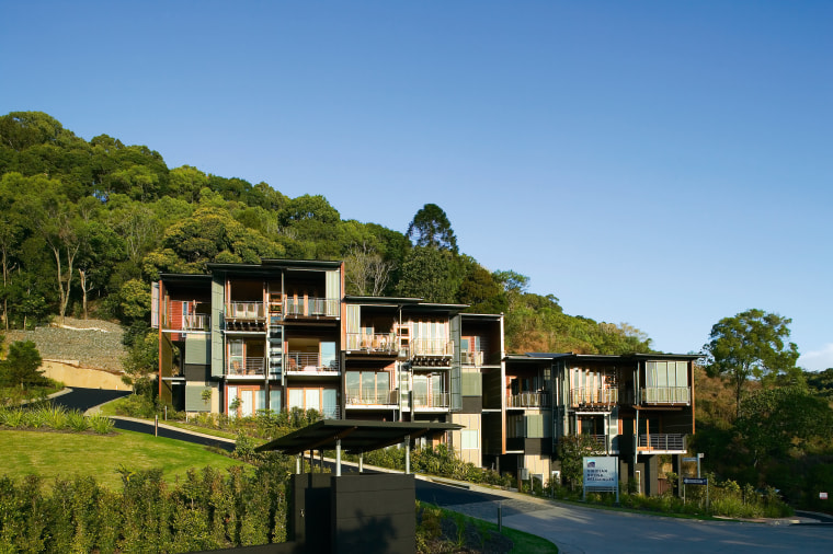 Exterior view of this new apartment block architecture, building, condominium, cottage, estate, home, house, plant, property, real estate, residential area, sky, tree, villa, teal, brown