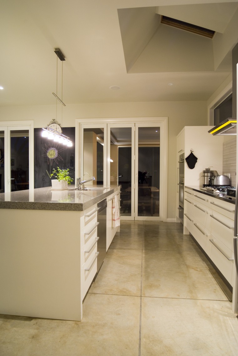 The designers specified hard-wearing, Peter Fell coloured concrete cabinetry, ceiling, countertop, cuisine classique, floor, flooring, hardwood, interior design, kitchen, laminate flooring, room, tile, wood flooring, orange, brown