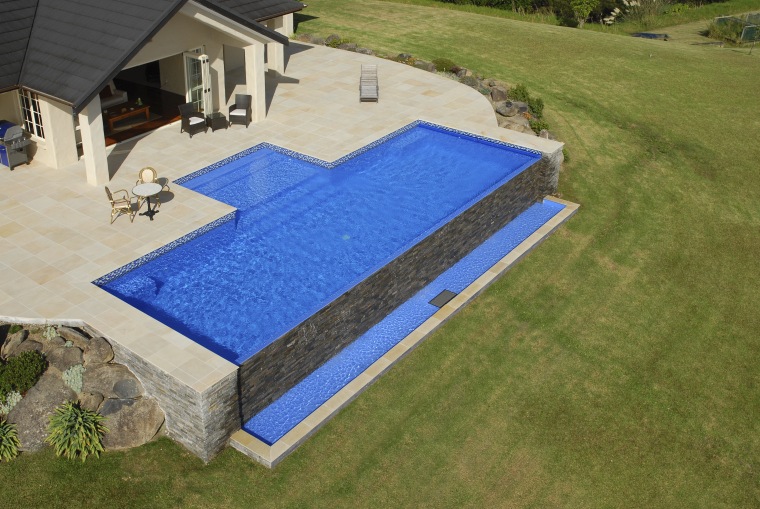 This is a view of the pool designed backyard, grass, house, lawn, leisure, outdoor furniture, property, real estate, roof, sunlounger, swimming pool, yard, brown