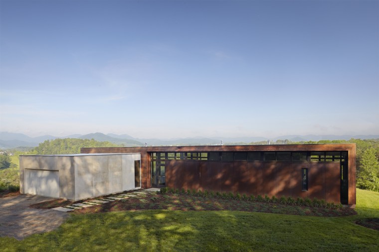Exterior of house with rusted corten steel. Sustainable architecture, cloud, estate, grass, home, horizon, house, land lot, landscape, property, real estate, rural area, sky, sunlight, teal