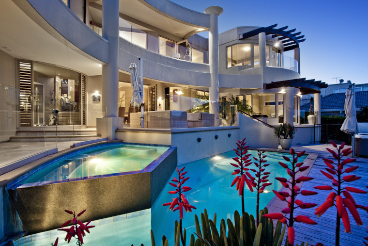 Water cascades down from an infinity edge pool, estate, home, hotel, leisure, leisure centre, property, real estate, resort, resort town, swimming pool, water
