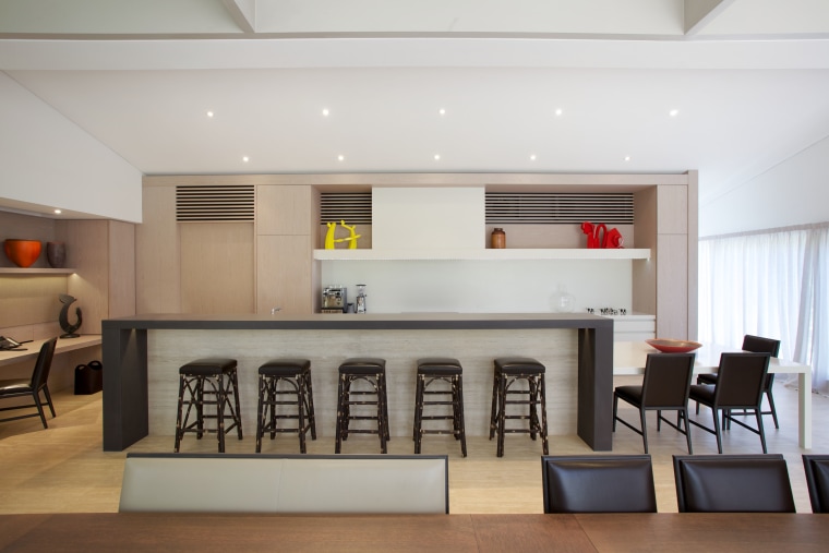 This kitchen's long island is extended further by ceiling, interior design, living room, table, gray