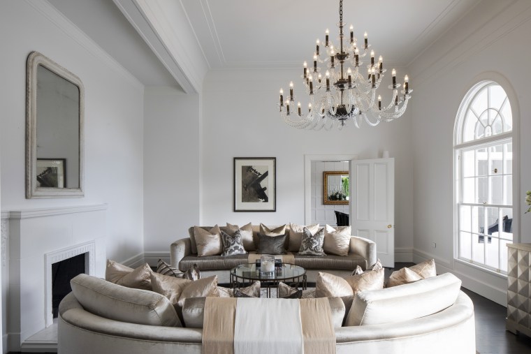 A large chandelier is the centrepiece of this ceiling, estate, furniture, home, interior design, living room, room, table, gray
