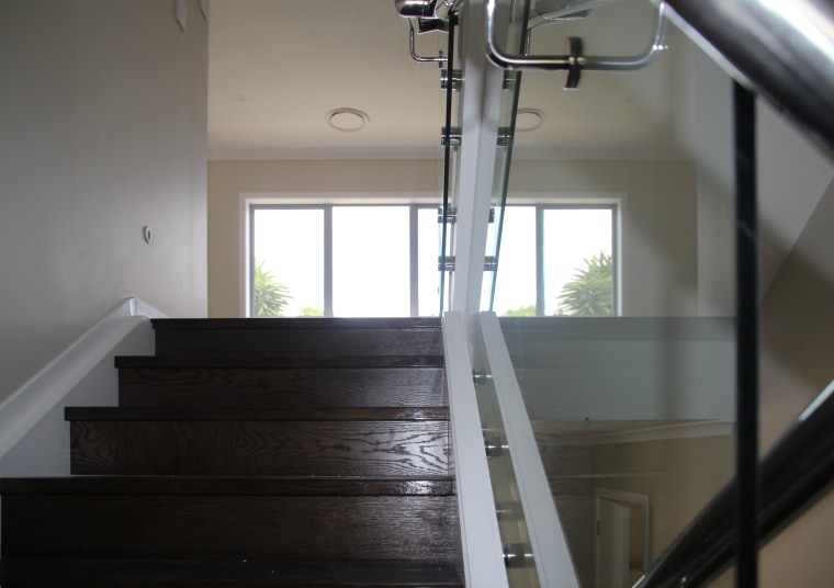 This home features an engineered dark oak staircase daylighting, floor, flooring, glass, handrail, hardwood, house, stairs, wood, gray, black