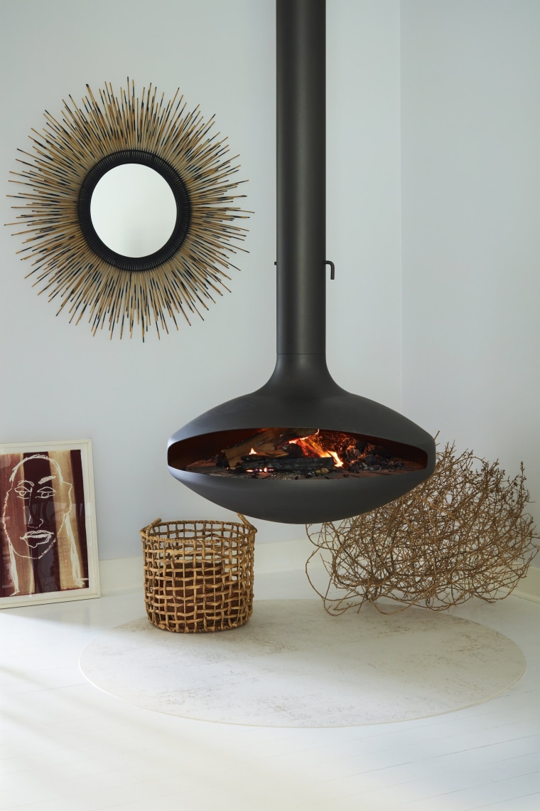 The fireplace hovers above a circular slab of room, gray