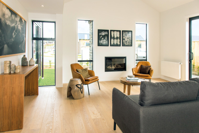 Creature comforts in this Wanaka showhome include a beige, building, ceiling, coffee table, couch, daylighting, den, estate, floor, flooring, furniture, hardwood, home, house, interior design, laminate flooring, living room, property, real estate, room, suite, table, wall, window, wood, wood flooring, white