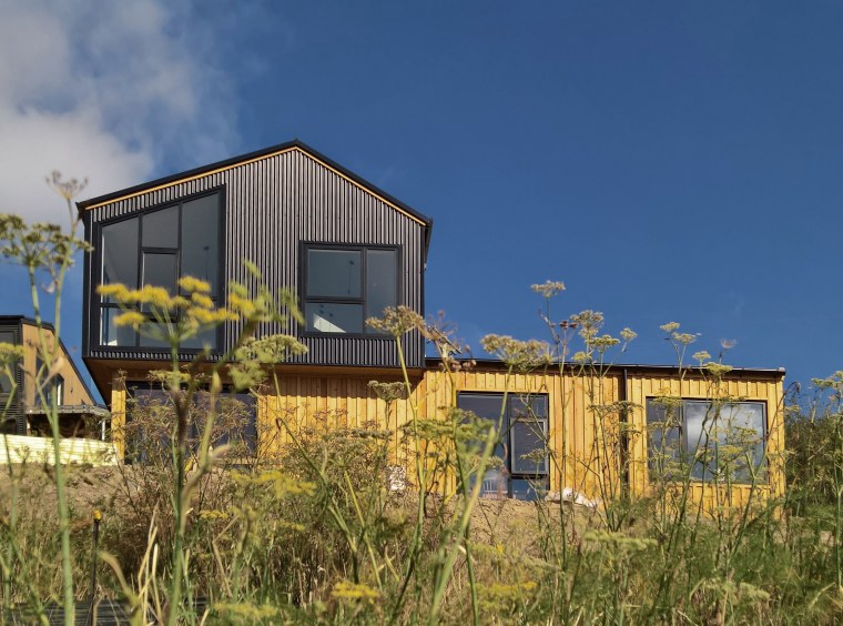 The Huntsbury House achieves a great street presence architecture, building, facade, grass, home, house, land lot, landscape, plant, plant community, real estate, roof, rural area, shack, shed, sky, tree, yellow, blue, brown