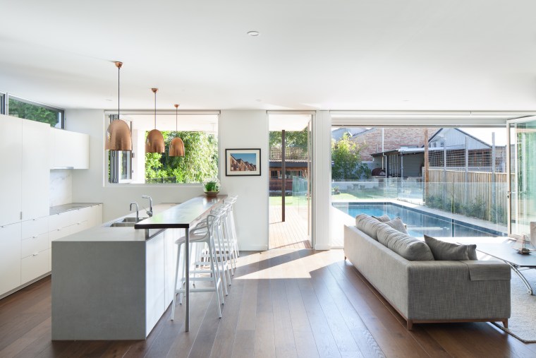 Light-filled and well-connected, this kitchen forms part of apartment, architecture, building, cabinetry, ceiling, countertop, daylighting, design, floor, flooring, furniture, hardwood, home, house, interior design, kitchen, living room, loft, property, real estate, residential area, roof, room, table, window, wood flooring, white