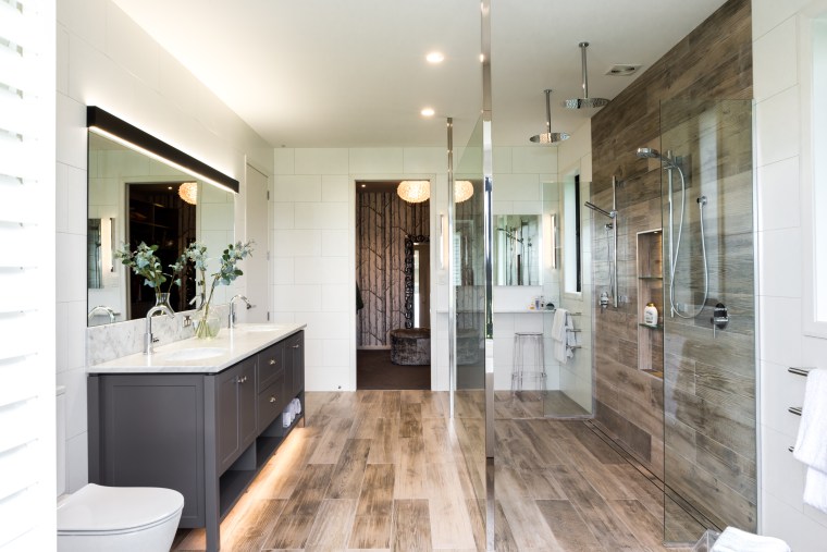 A dressing room accessed by both the master bathroom, building, ceiling, door, estate, floor, flooring, furniture, hardwood, home, house, interior design, loft, property, real estate, room, tile, wood flooring, white, gray