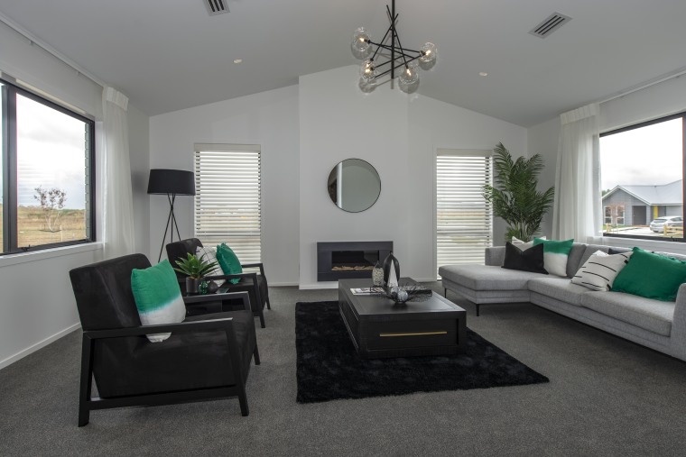 This Fowler Homes Waikato showhome is warm year-round building, ceiling, ceiling fan, coffee table, den, floor, furniture, green, hardwood, home, house, interior design, living room, mechanical fan, property, real estate, room, table, gray, black