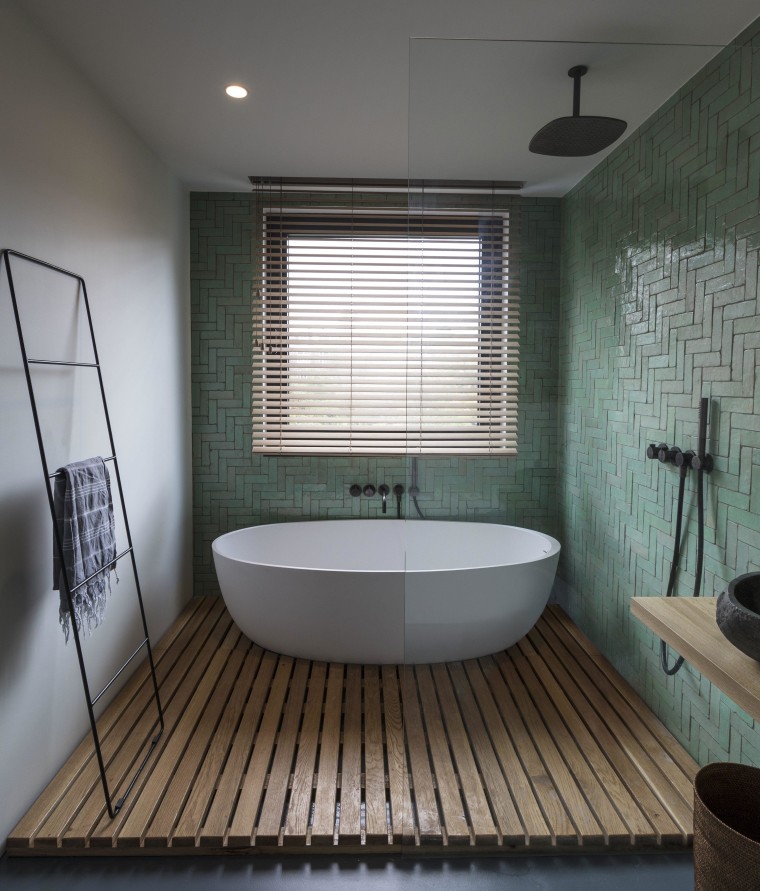 This bathroom’s wet area containing the bath tub architecture, bathroom, bathtub, building, ceiling, daylighting, floor, flooring, home, house, interior design, plumbing fixture, property, room, tile, gray, black