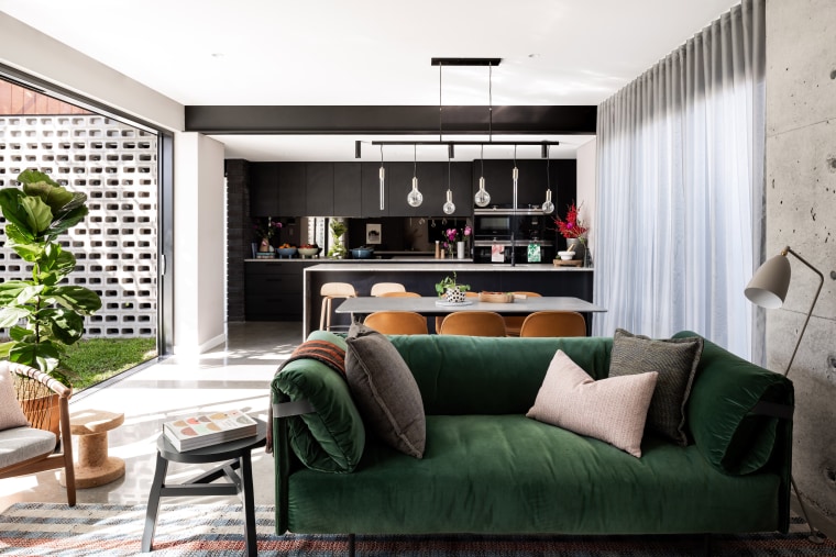 This living zone’s dark tones balance the natural architecture, coffee table, couch, floor, furniture, living room, home, house, interior design, shelf, shelving, table, wall, white, black, Dalecki Design