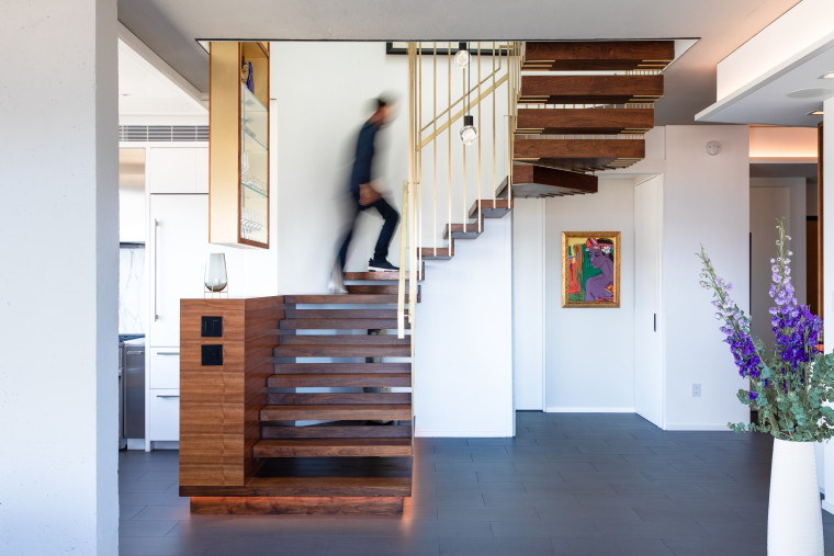 Reconfiguring the stairs was a major contributor to architecture, building, ceiling, floor, flooring, furniture, hall, hardwood, home, house, interior design, loft, room, stairs, wood, white