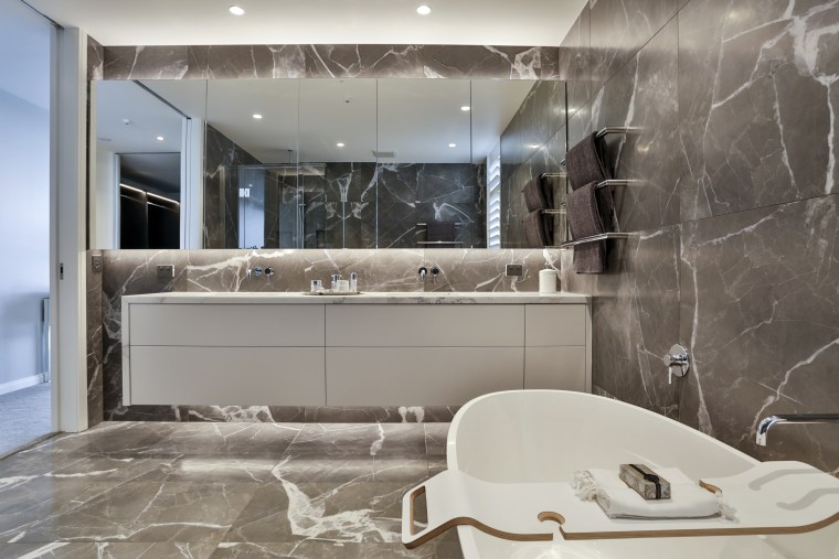 For this bathroom by Dunlop Design, the double architecture, bathroom, bathroom accessory, bathtub, building, ceiling, floor, flooring, furniture, home, house, interior design, marble, material property, plumbing fixture, property, real estate, room, sink, tap, tile, wall, gray