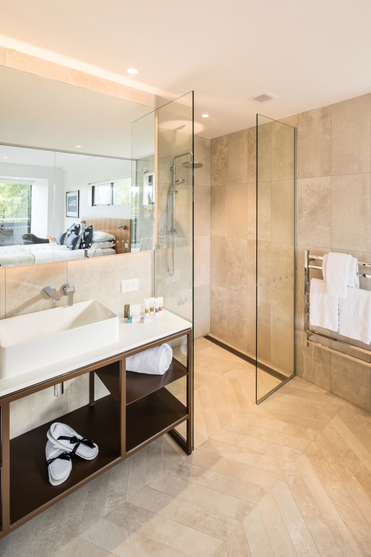Clean-lined and contemporary, this custom steel-framed vanity is apartment, architecture, bathroom, beige, building, ceiling, floor, flooring, furniture, home, house, interior design, material property, plumbing fixture, property, real estate, room, tile, white, orange