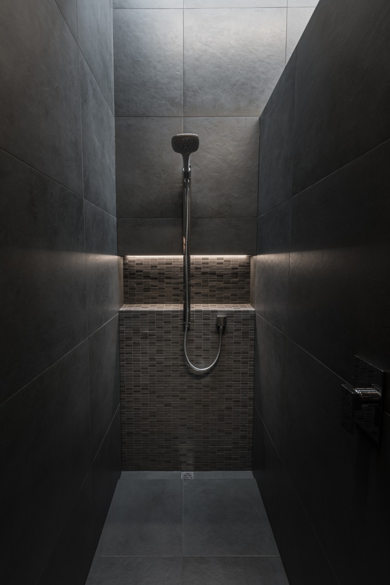The layout incorporates a practical and private shower architecture, bathroom, black, concrete, floor, flooring, interior design, line, plumbing fixture, room, shower, tile, black