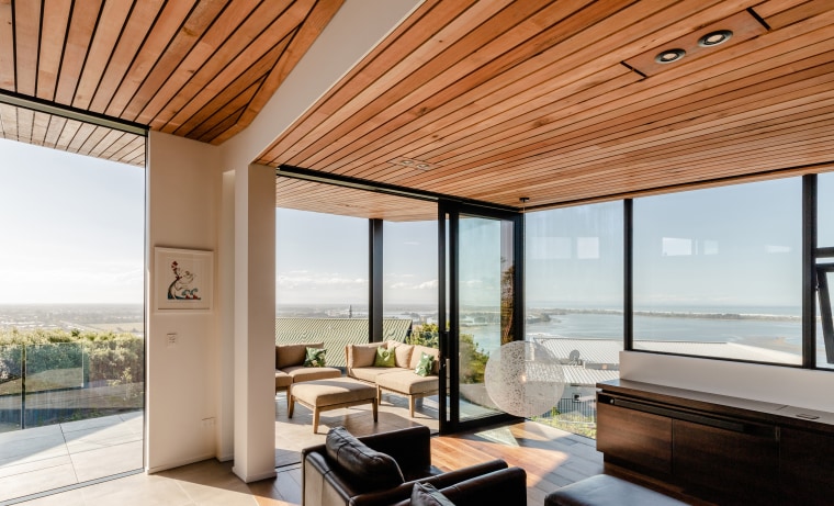 The insulation installed in The Wall House’s envelope apartment, architecture, building, ceiling, coffee table, daylighting, door, estate, facade, floor, furniture, hardwood, home, house, interior design, living room, penthouse apartment, property, real estate, roof, room, shade, table, window, white, orange