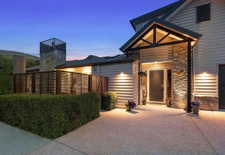 Superb lighting highlights this entranceway featuring Niagara's timber cottage, elevation, estate, facade, home, house, lighting, property, real estate, residential area, roof, siding, window, gray