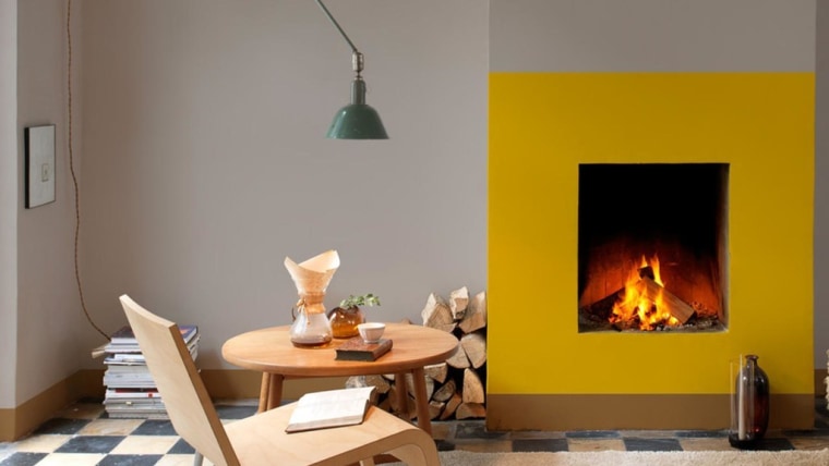 What could have been a forgettable fireplace was fireplace, furniture, hearth, heat, home, interior design, living room, orange, room, table, wood-burning stove, gray