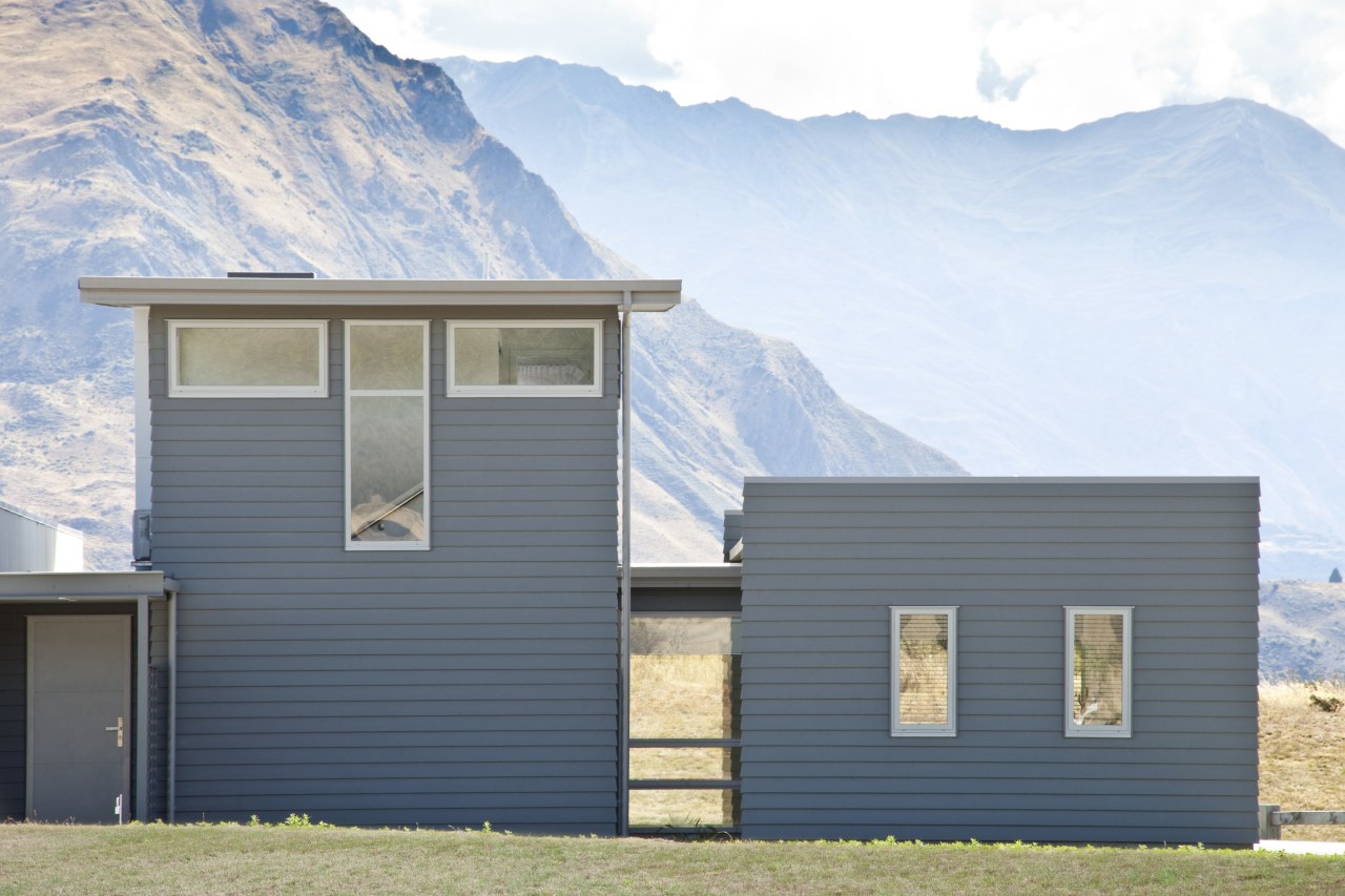 exterior of house at rear, otago mountains in architecture, building, cottage, elevation, facade, farmhouse, home, house, hut, property, real estate, siding, sky, window, white