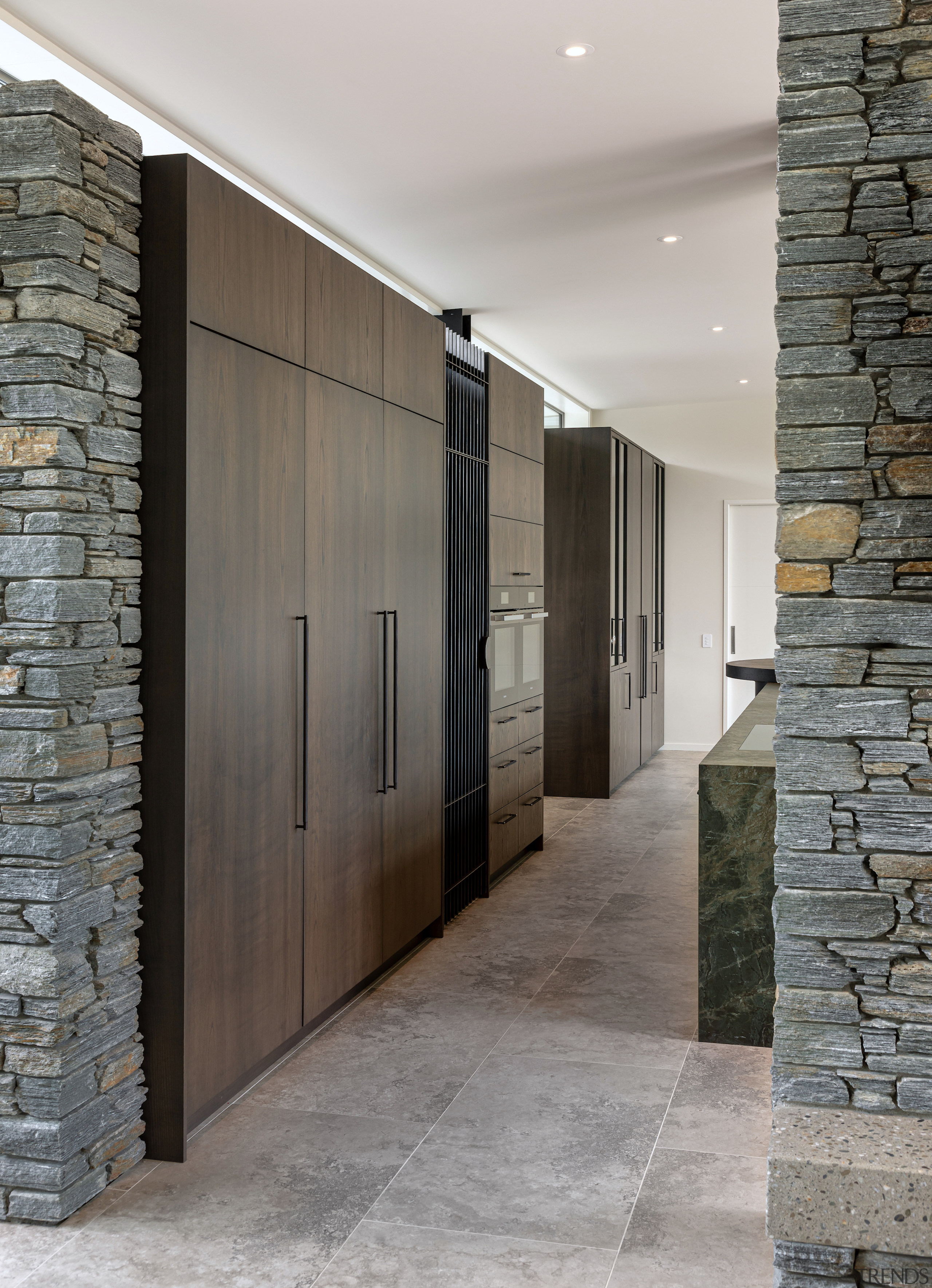Wall of closed wood-veneer cabinets behind the kitchen 