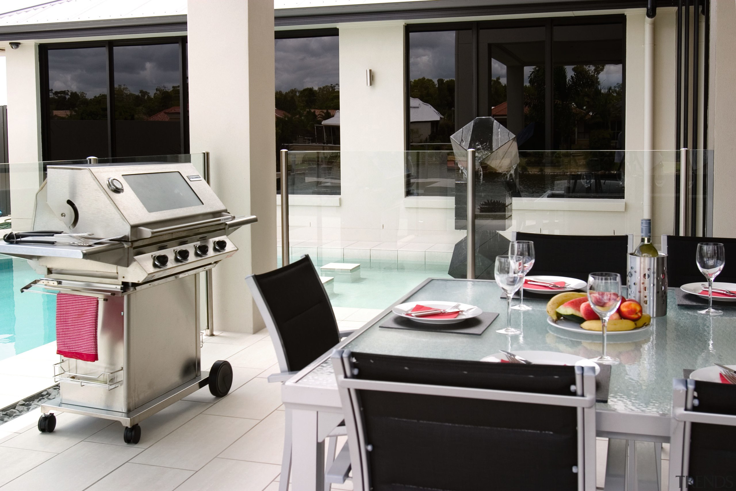 Outdoor patio and pool area with dining table, kitchen, window, white, black, gray